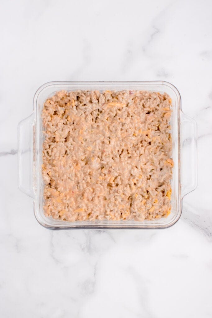 Big Mac ground beef mixture spread evenly in a square glass casserole dish.