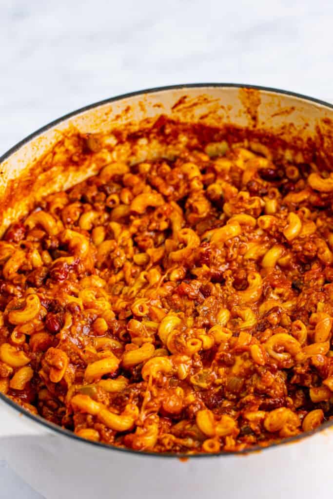 Chili Mac with ground beef, beans, elbow macaroni, and melted cheese in a Dutch oven