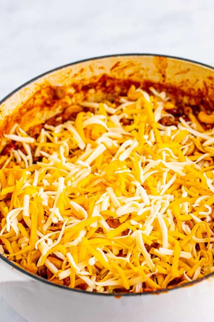 More shredded cheese added over the top of homemade Chili Mac
