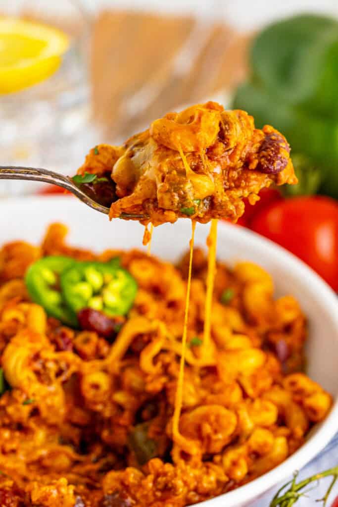 Spoonful of cheesy Chili Mac with ground beef, beans, and stretchy melted cheese