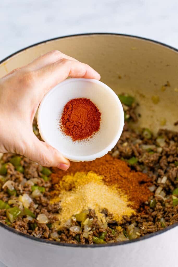 Smoked paprika being added to the seasoned ground beef mixture