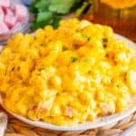 A serving of creamy macaroni and cheese with diced ham.