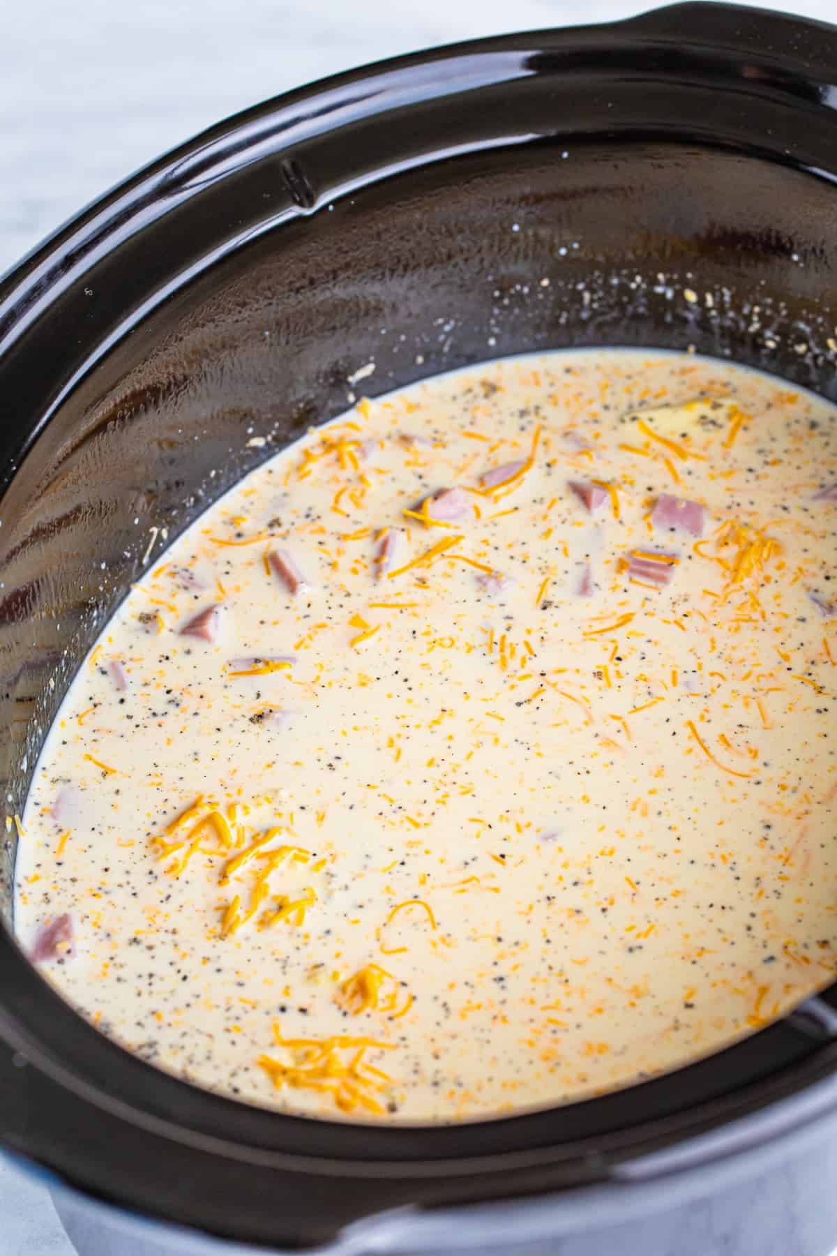 Step 2 of making slow cooker ham mac and cheese.