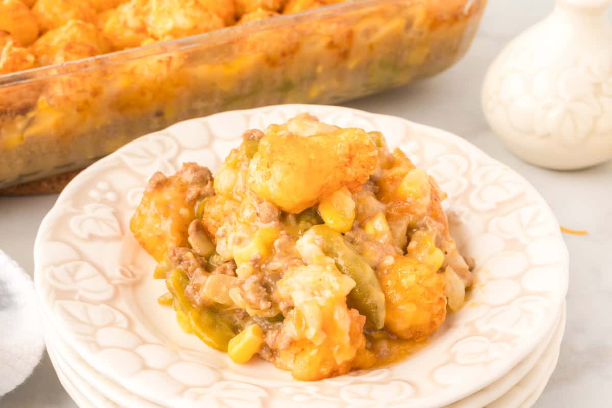 Baked tater tot casserole topped with melted Cheddar cheese