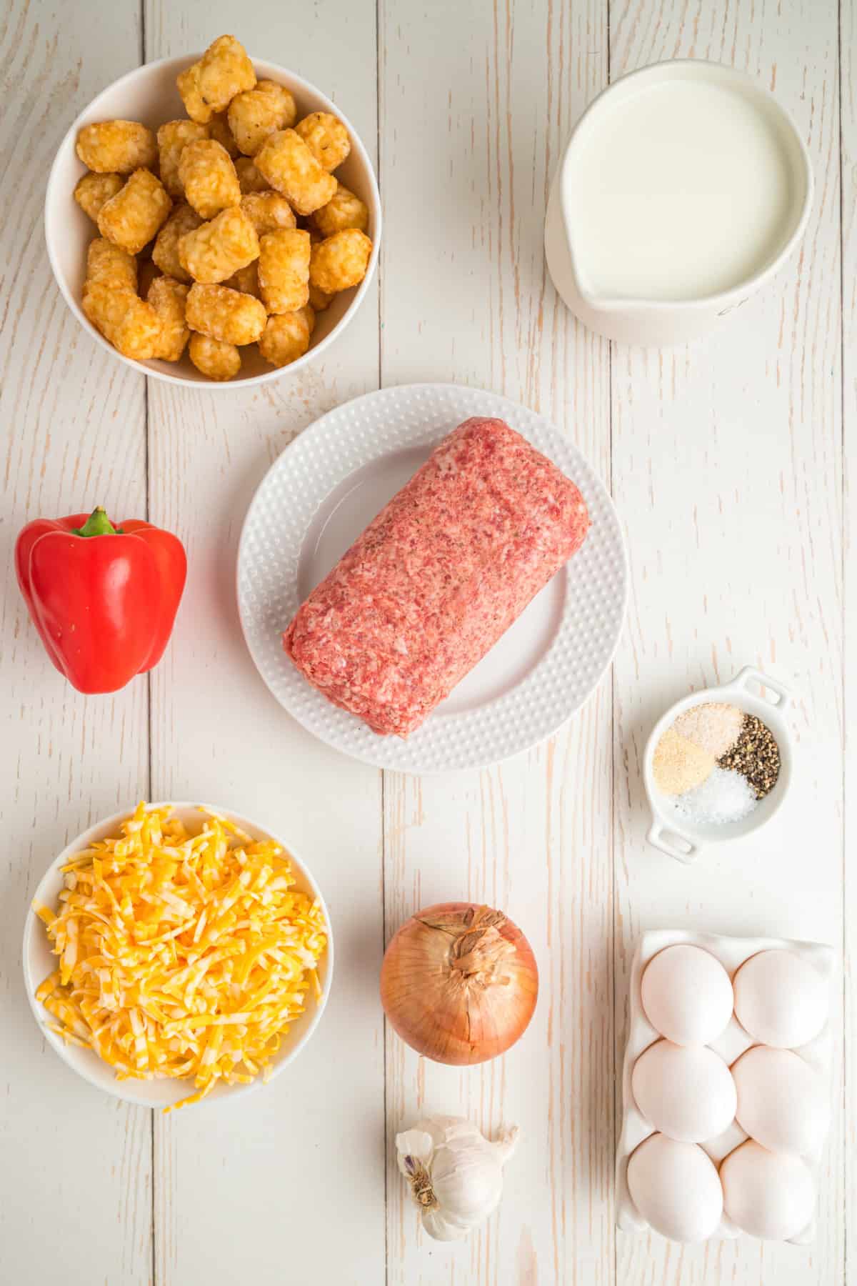 Tater tots, sausage, eggs, milk, Colby Jack cheese, onion, bell pepper, garlic, and seasonings for breakfast casserole.