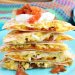 A close up view of the finished breakfast quesadillas recipe with salsa and sour cream ready to be shared!